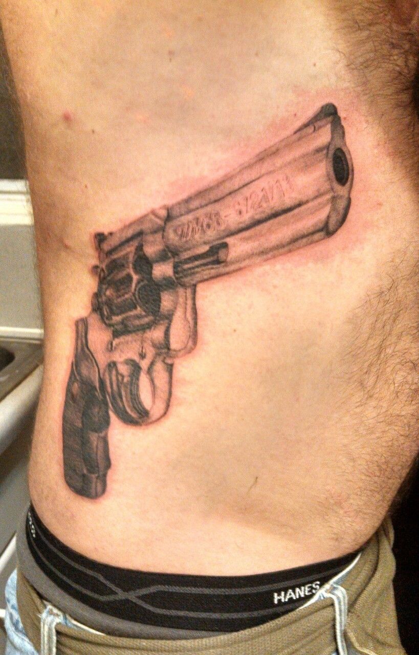 Small revolver tattoo on the arm - Tattoogrid.net