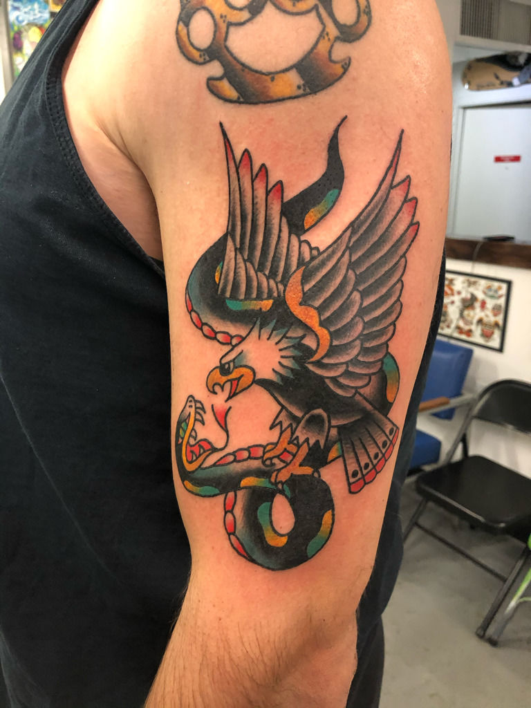 Traditional eagle and cobra fight tattoo on the