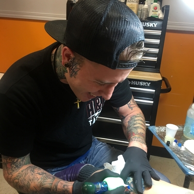 Florida Memory  Tattoo artist Jon Fort dipping the needle into ink   Pensacola Florida